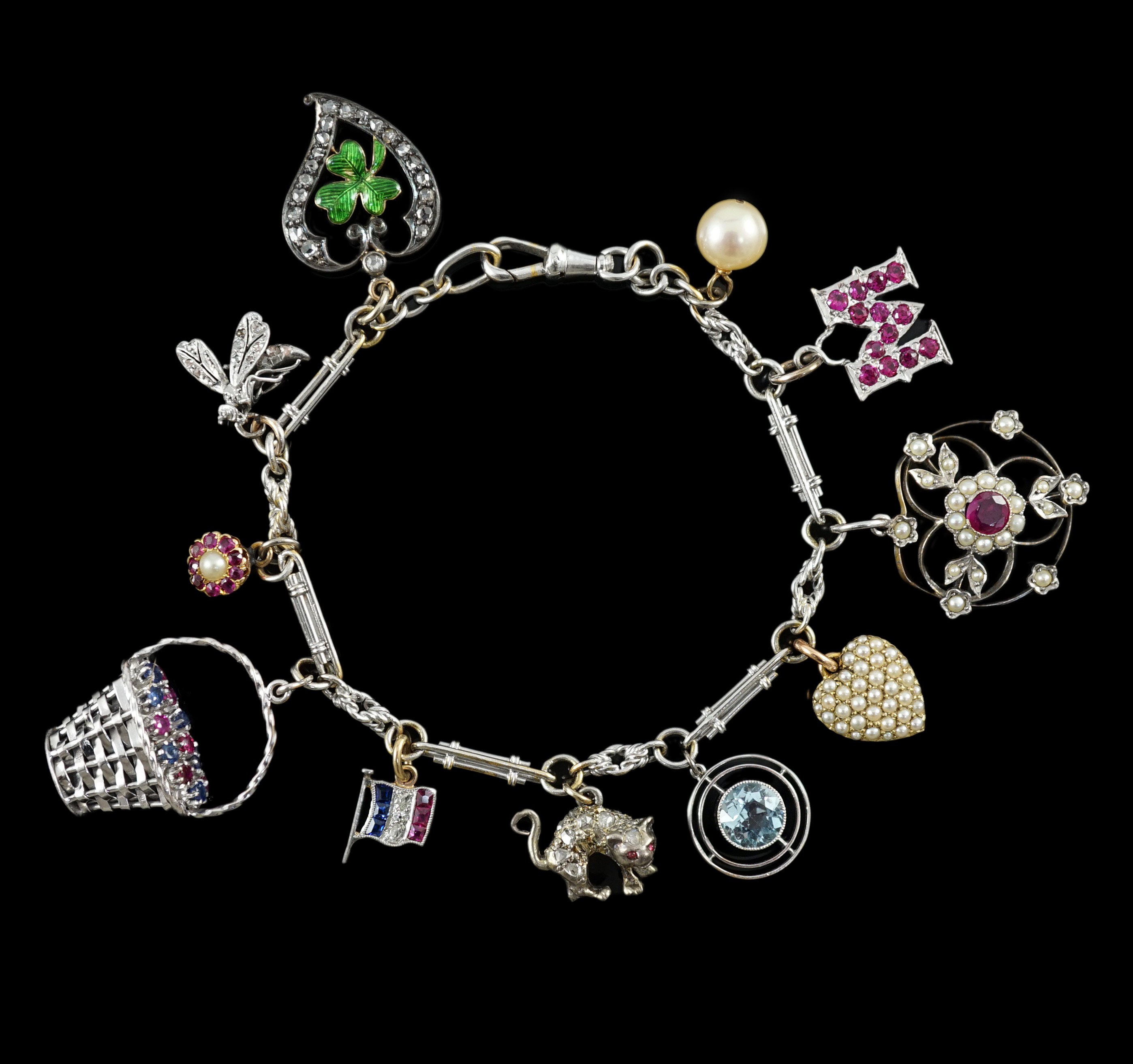 A French 18ct white gold circular and baton link charm bracelet, hung with eleven assorted charms